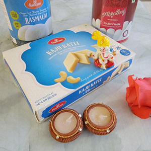 Diwali hamper with cham cham, rasmalai, kaju katli, diya and Ganesh ji idol