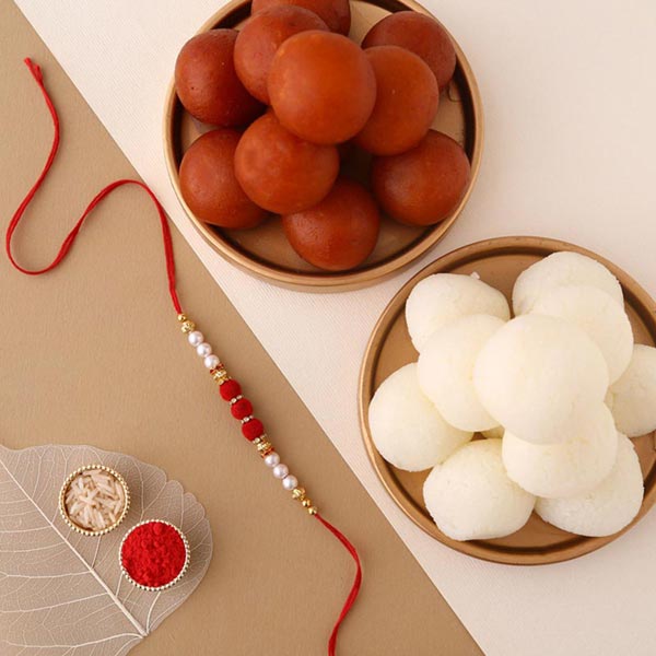 Send Sneh White Pearls Rakhi & Sweets Tin Online